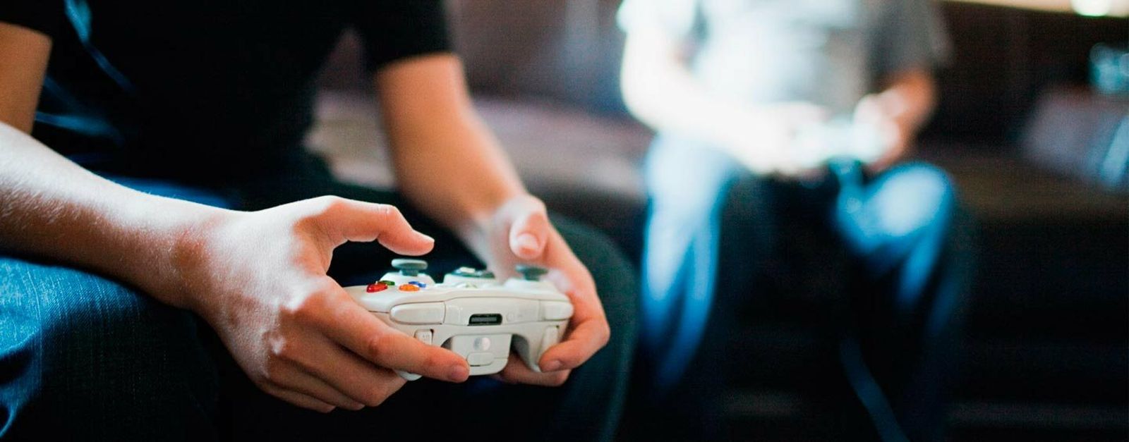 Un joven con un mando de videojuegos en sus manos.