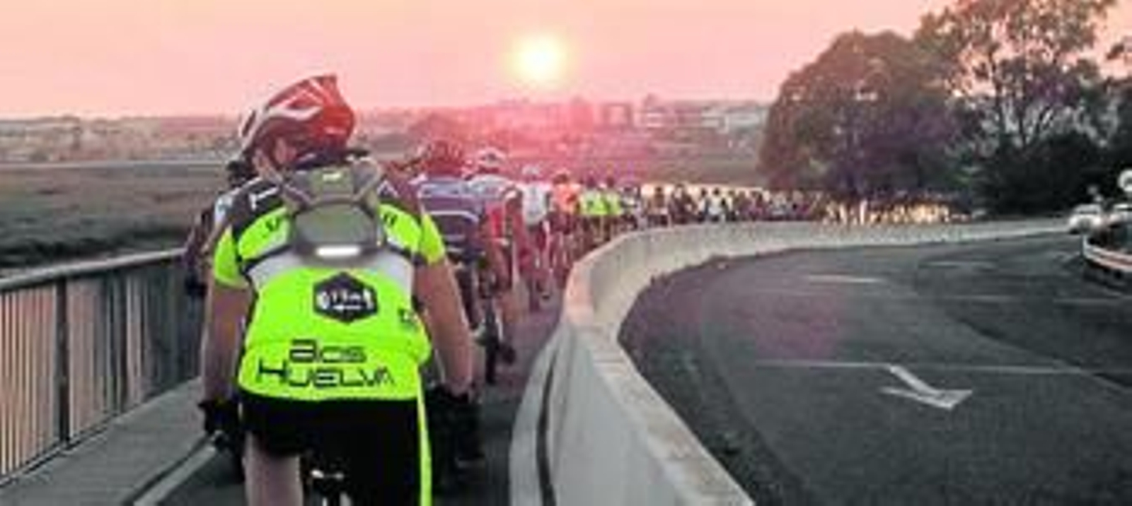 Los ciclistas, cruzando el puente sifón a la caída de la tarde.