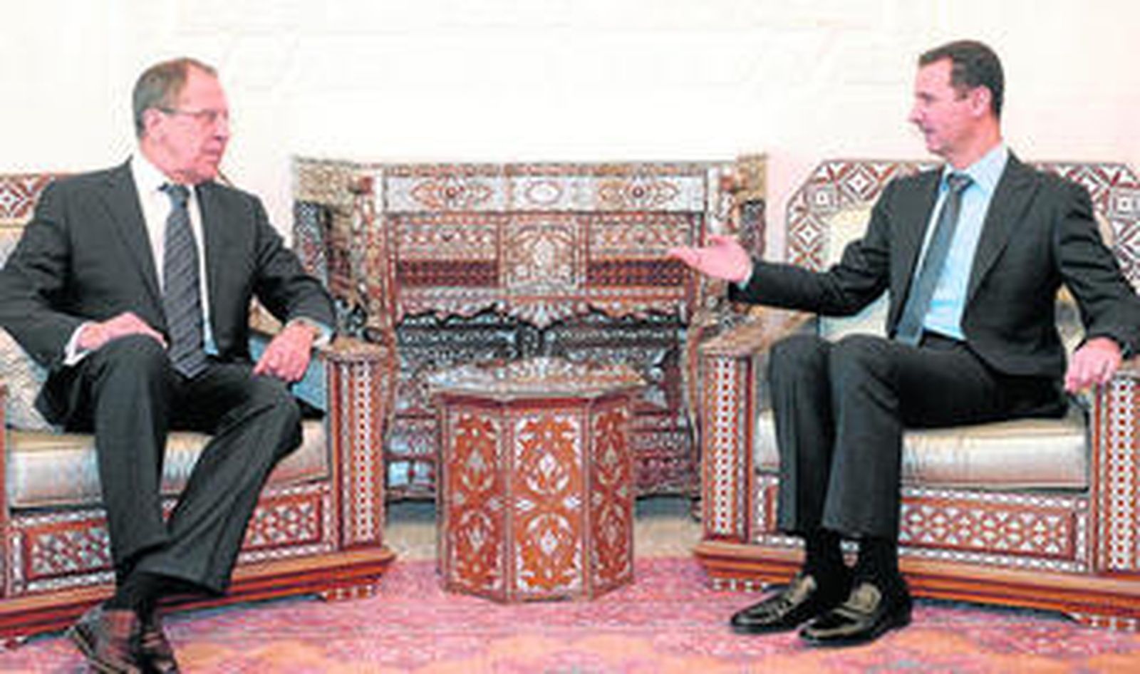 El presidente sirio, Bashar al Asad (dcha.), y el ministro de Exteriores ruso, Sergei Lavrov, dialogan durante el encuentro de ayer en Damasco.