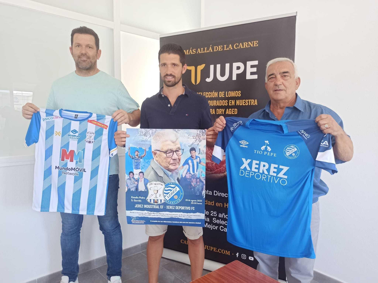 Pedro Herrera posa con el cartel junto a Juan Manuel Queijo, presidente del Jerez Industrial y Jesús Viloita, vicepresidente del Xerez DFC.