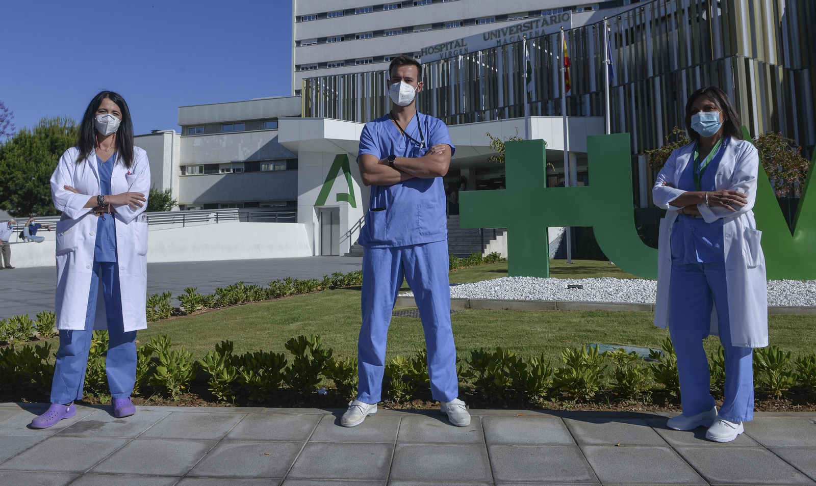 El enfermero del Macarena Antonio Hicke junto a dos compañeras a las puertas del hospital.