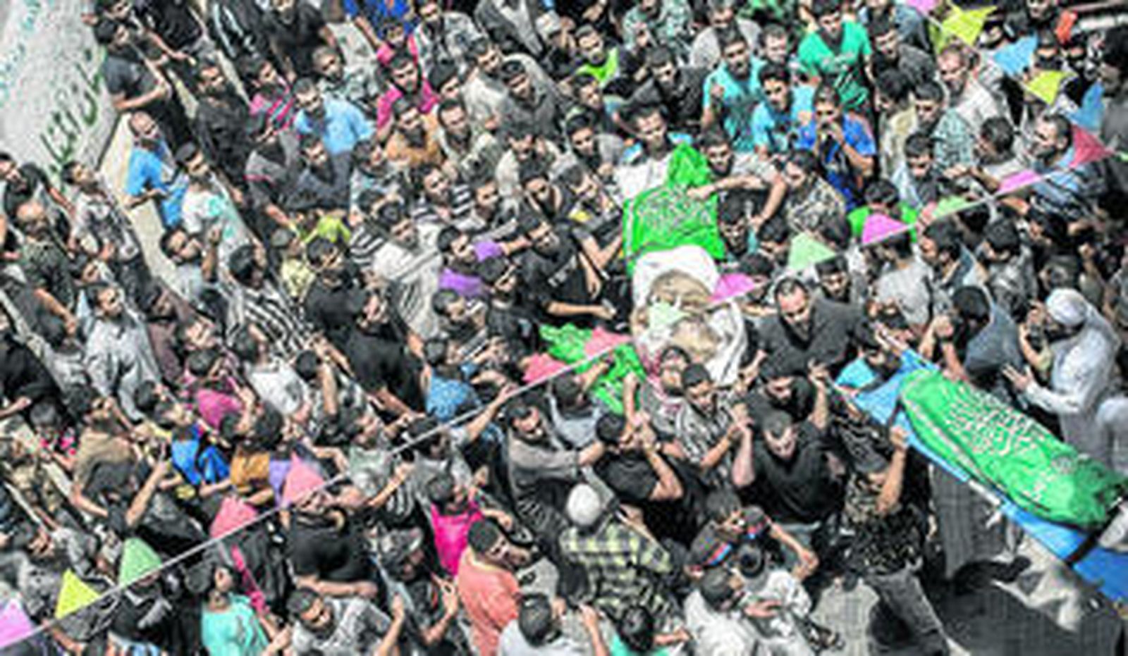 Decenas de palestinos agasajan los féretros de dos víctimas de los ataques aéreos de Israel en Gaza.