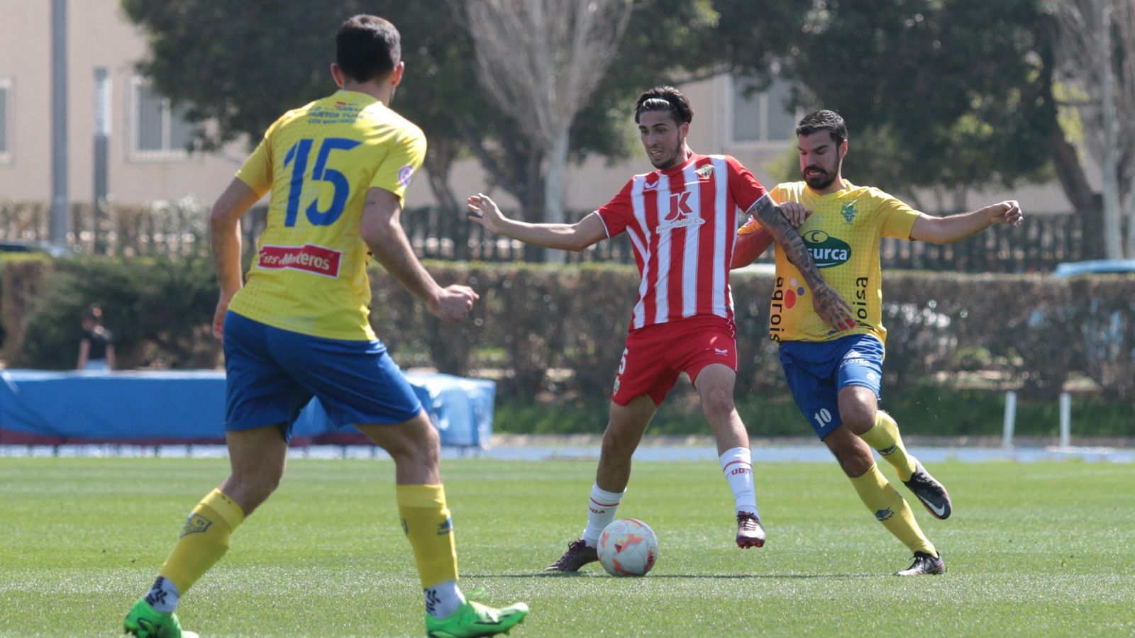 Carmona protege el esférico ante la presión de un rival.