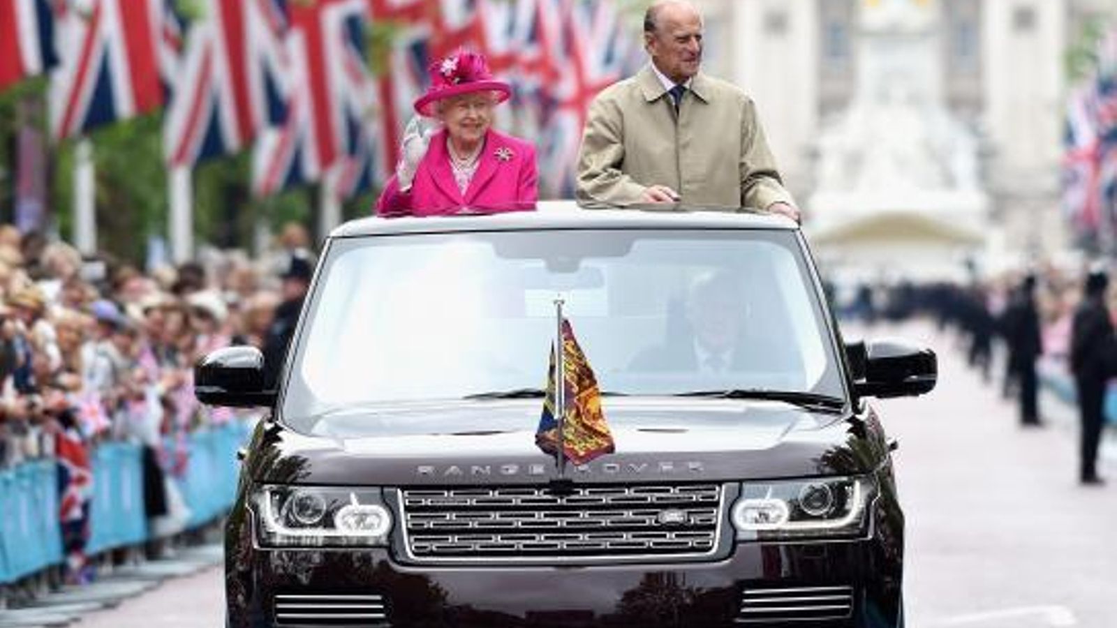 La reina Isabel II y el príncipe Felipe de Edimburgo saludan desde un Range Rover State Review