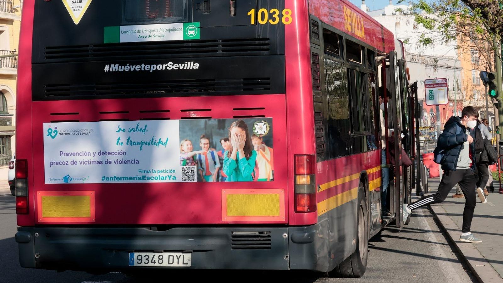 Un autobús de Tussam con el cartel de la campaña #EnfermeraEscolarYa del Colegio de Enfermería.