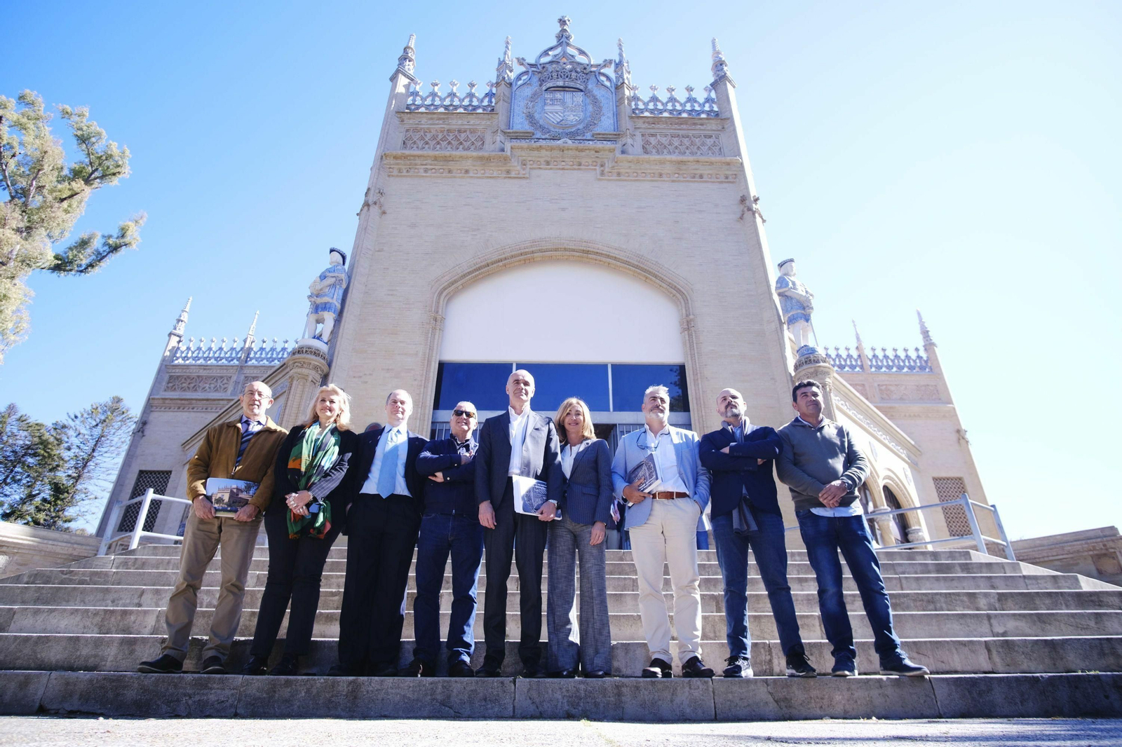 Los participantes en la presentación del catálogo posan ante el Pabellón Real.