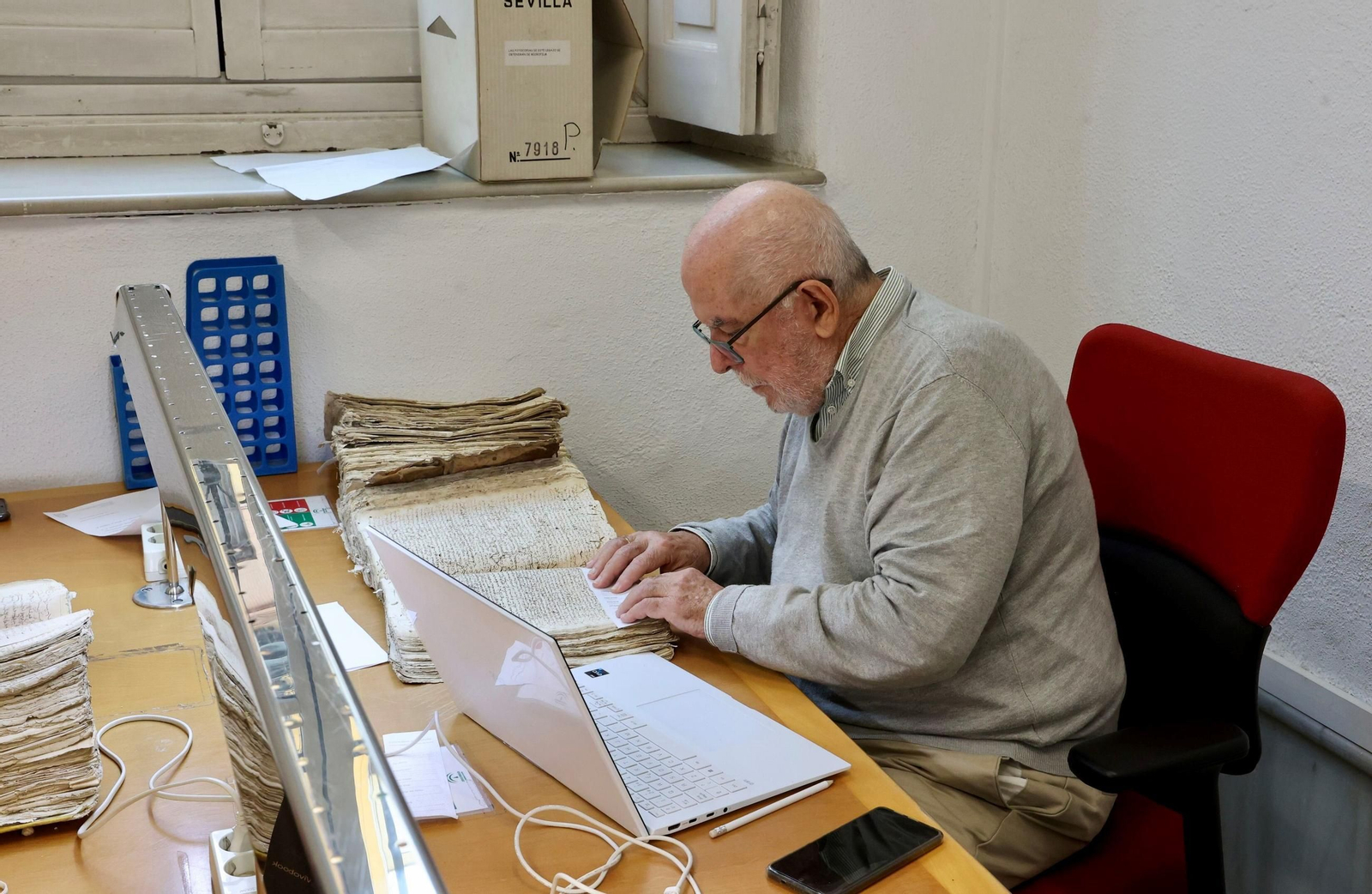 El investigador, académico y filólogo Juan Gil consultando uno de los libros del archivo.