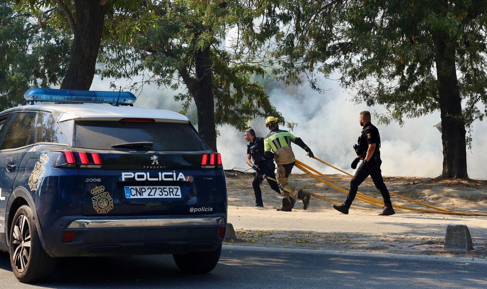 Policías nacionales y bomberos trabajan en el incendio del auditorio Rocío Jurado.