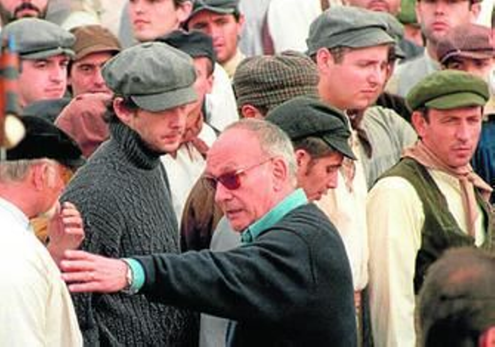 Mario Camus da instrucciones a los extras durante el rodaje de la película 'La ciudad de los prodigios'.
