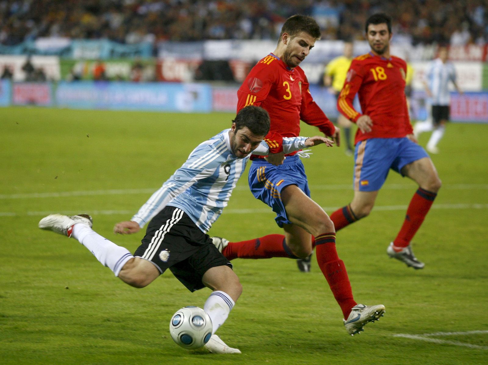 Higuaín ante Piqué en un amistoso de 2009