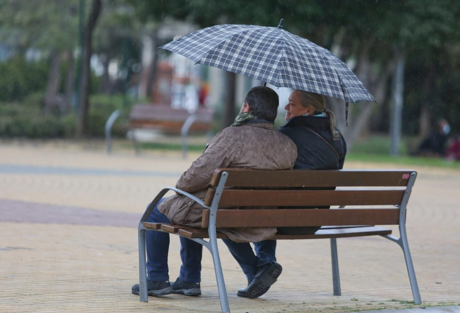 Dos personas bajo un paraguas en Málaga Dos personas bajo un paraguas en Málaga