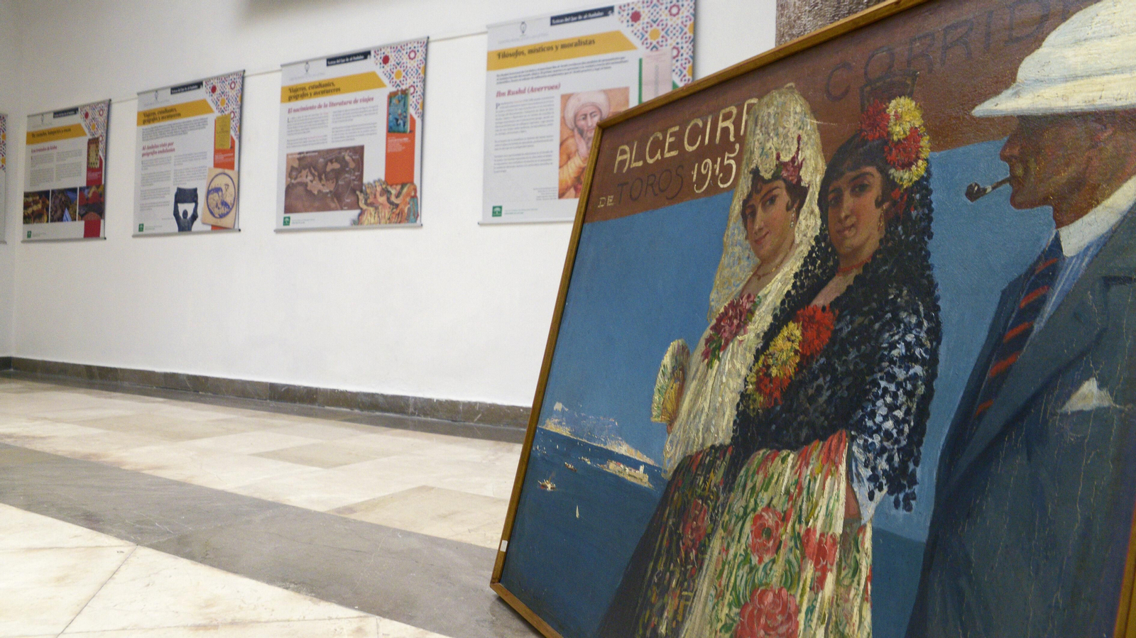 Cartel de la Feria taurina de Algeciras 1915 Óleo sobre lienzo de Mariano Bertuchi con escena de dos mujeres ataviadas con trajes de fiesta de principios de siglo y un hombre.