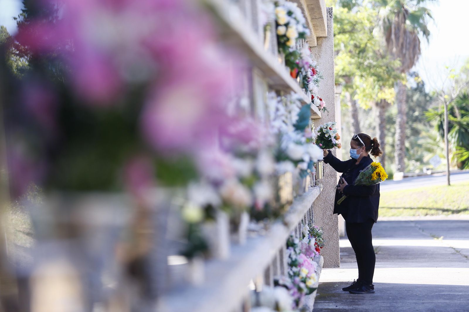 Una mujer lleva flores a sus familiares en Parcemasa.