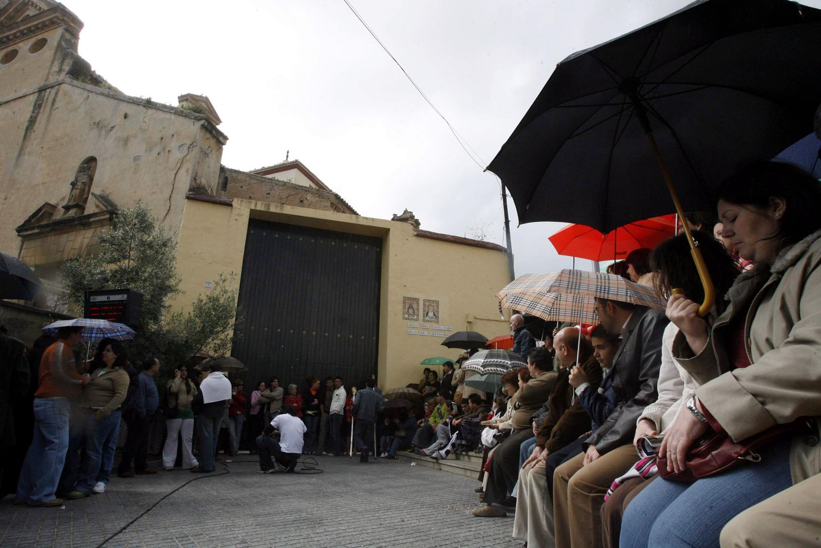 Imagen de archivo de personas con paraguas  esperando en la puerta de la nave de los Trinitarios la salida del Rescatado.
