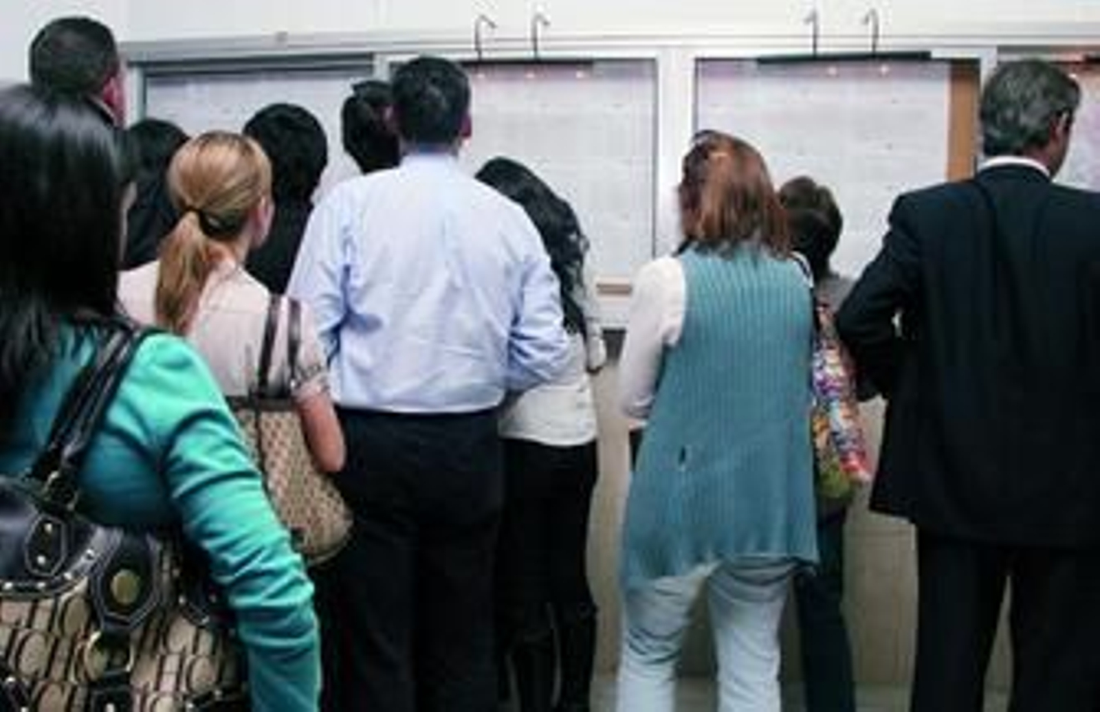 Varias familias comprueban el listado de puntos obtenidos en un colegio de la capital.