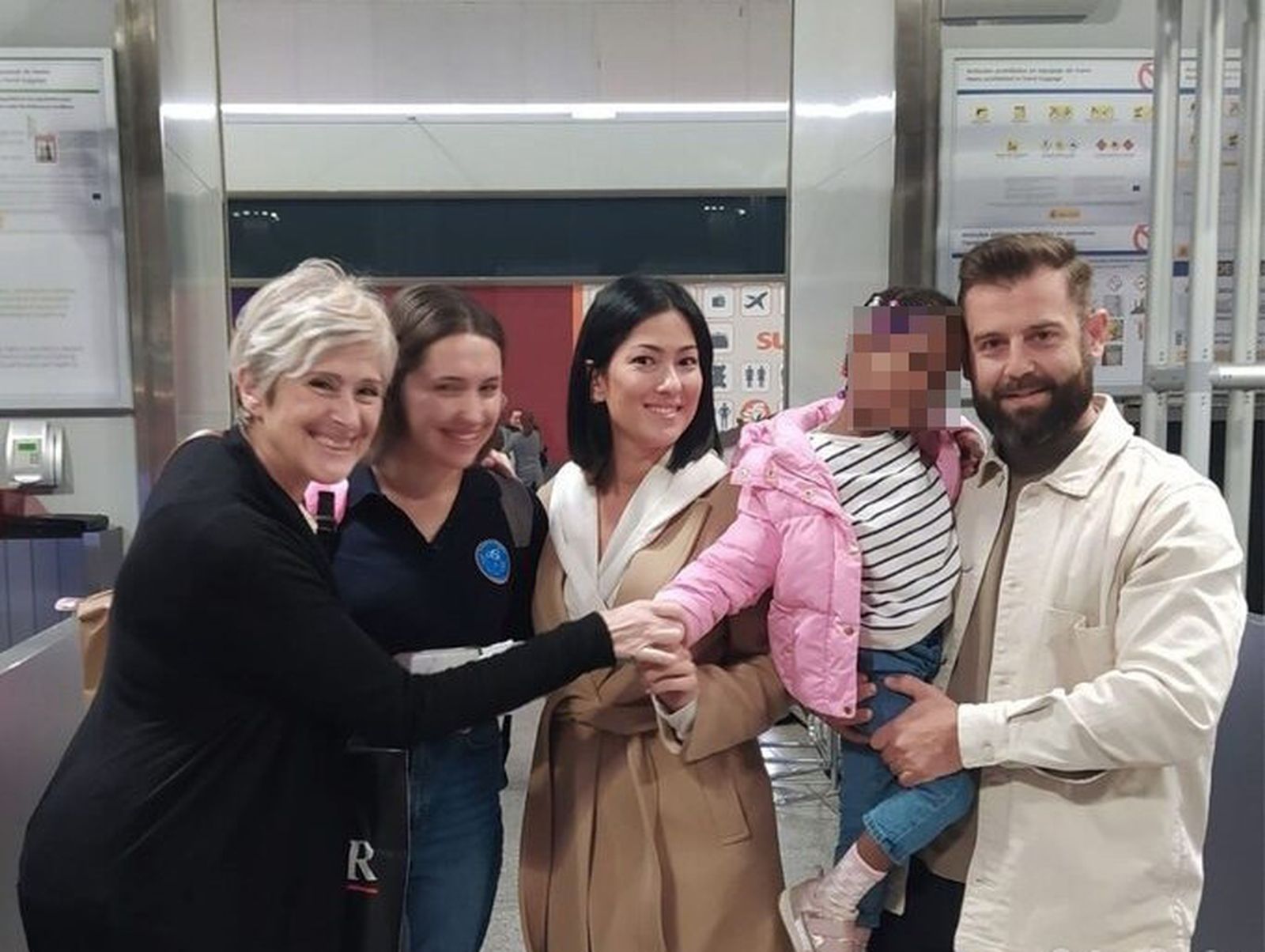 La niña, con su familia de acogida y representantes de Tierra de Hombres en el aeropuerto.
