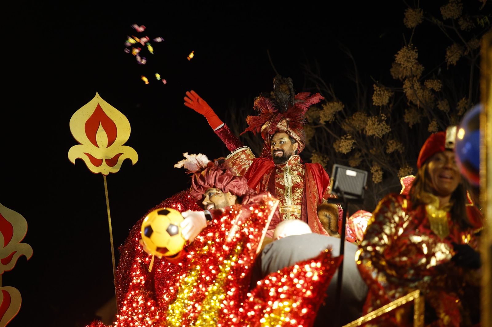 El Rey Baltasar lanzando caramelos desde su carroza.