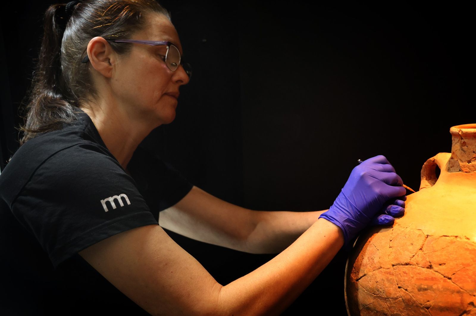 Trabajadora del Museo trabajando una de las piezas antes de exponerlas.