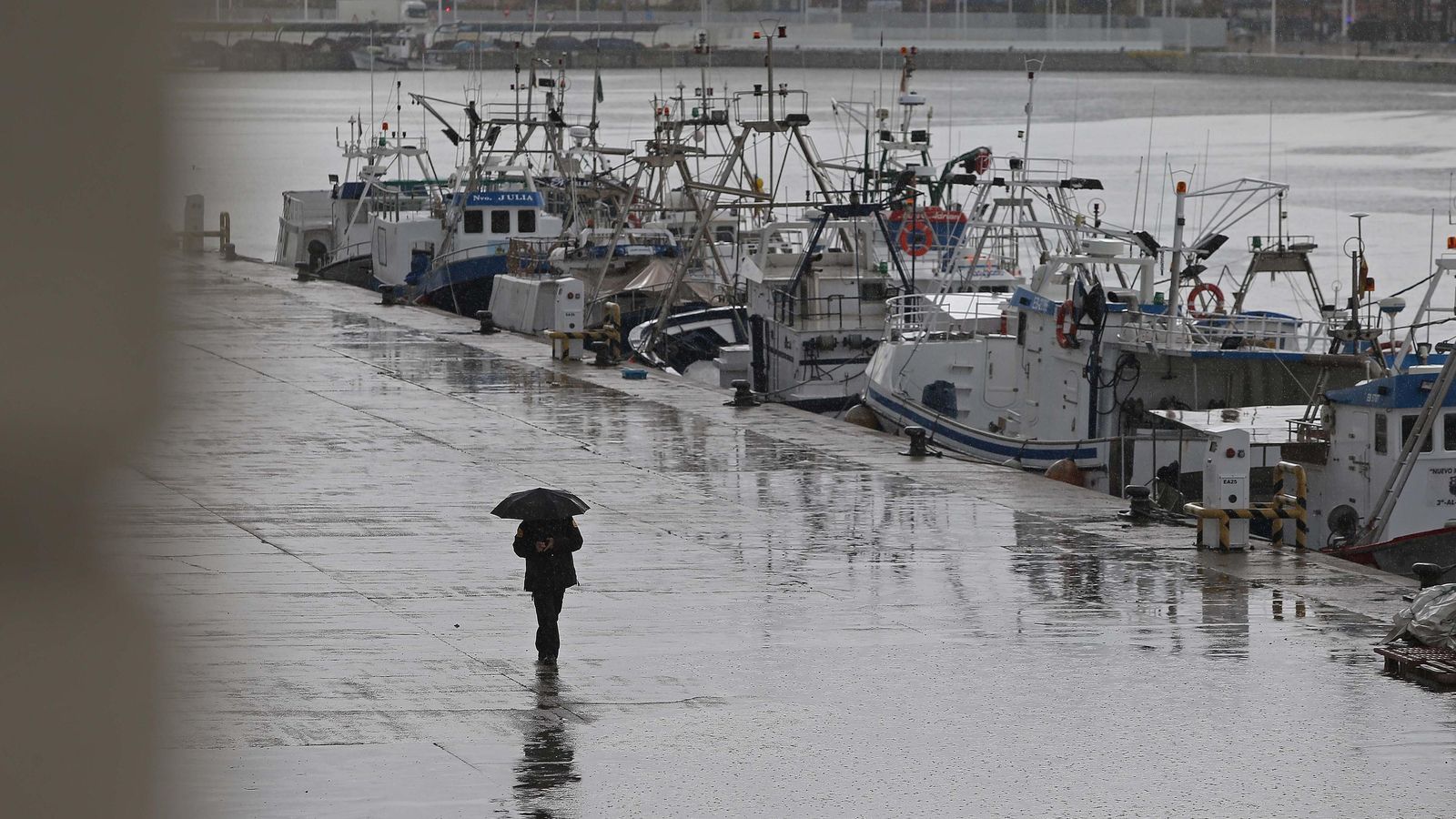 Un hombre camina por la dársena pesquera de Algeciras.