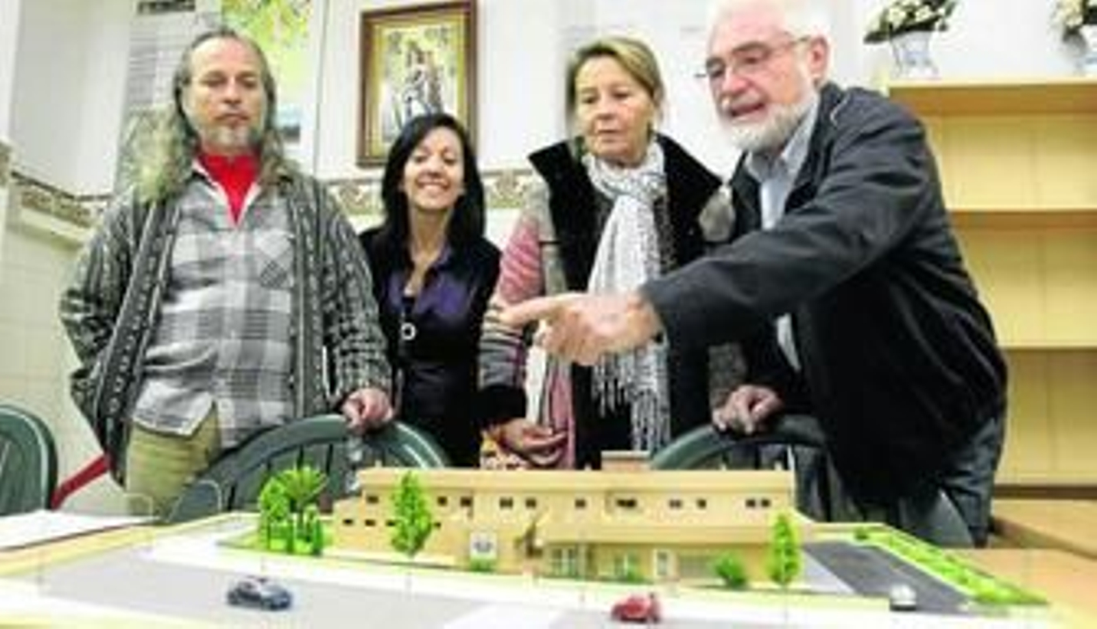 Miembros de la junta directiva de Calor y Café muestran la maqueta de su proyecto.