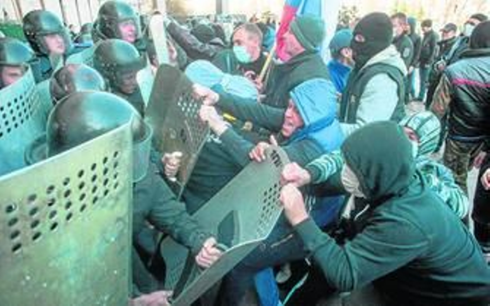 Manifestantes prorrusos forcejean con la Policía mientras intentan ocupar la sede de la Administración regional en Donetsk.