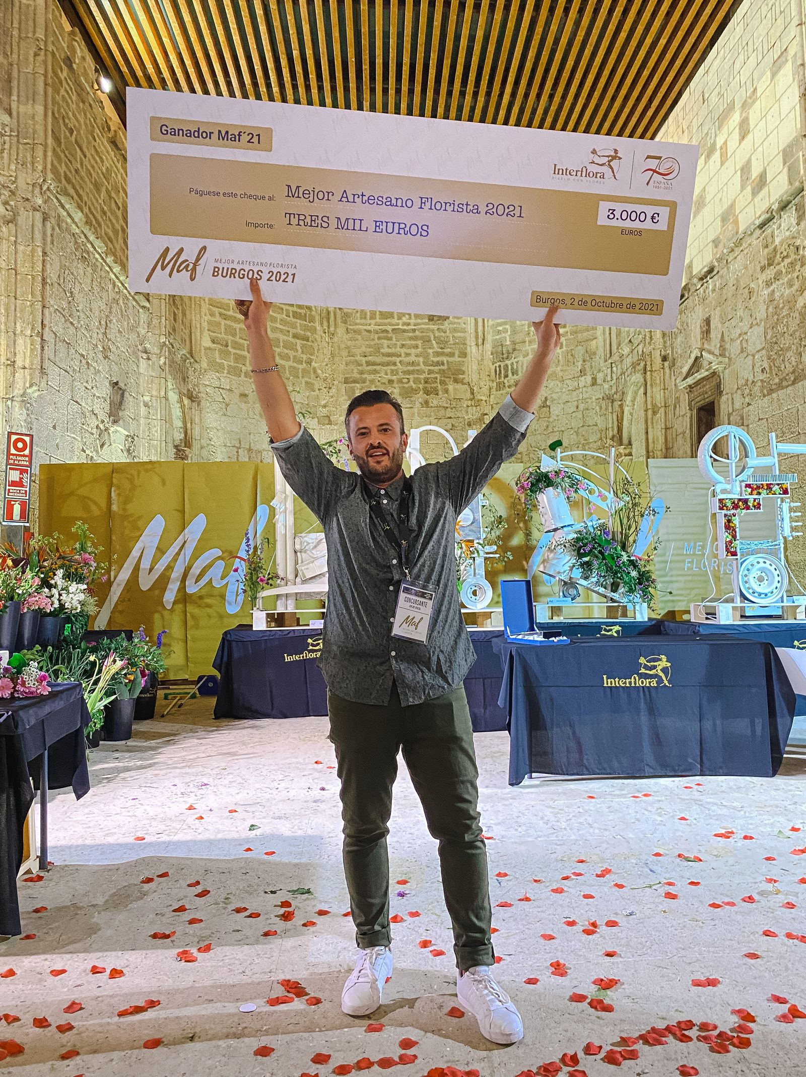 Julio Boza muestra el cheque de ganador del certamen organizado por Interflora.