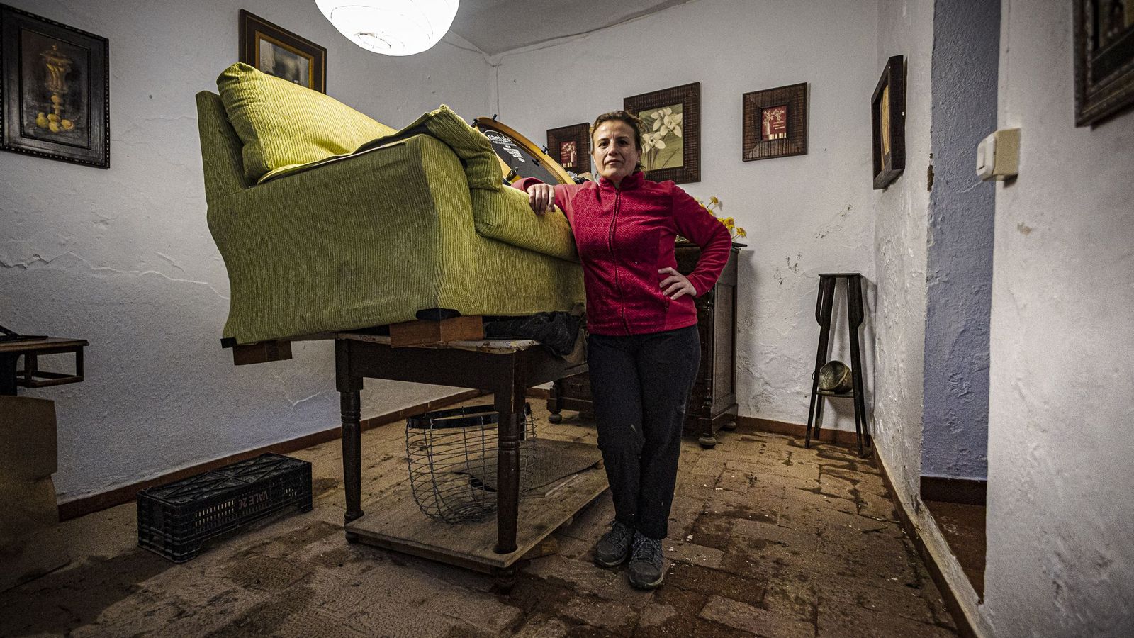 Una de las vecinas de Grazalema que ayer regresó a su casa, Paqui, junto al sofá y otros muebles de la casa que tuvo que poner en alto para evitar que se mojaran con el agua