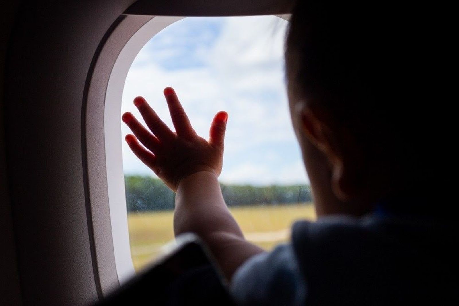 Bebe mirando por la ventana de un avión