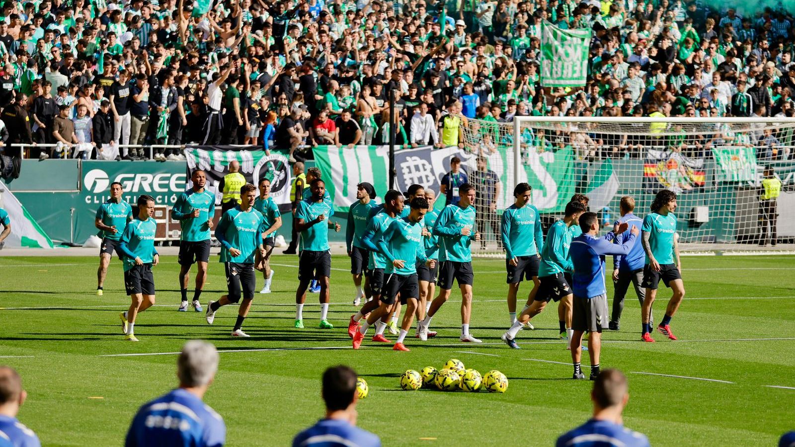 Los futbolistas del Betis realizan carrera de calentamiento al calor de sus aficionados.