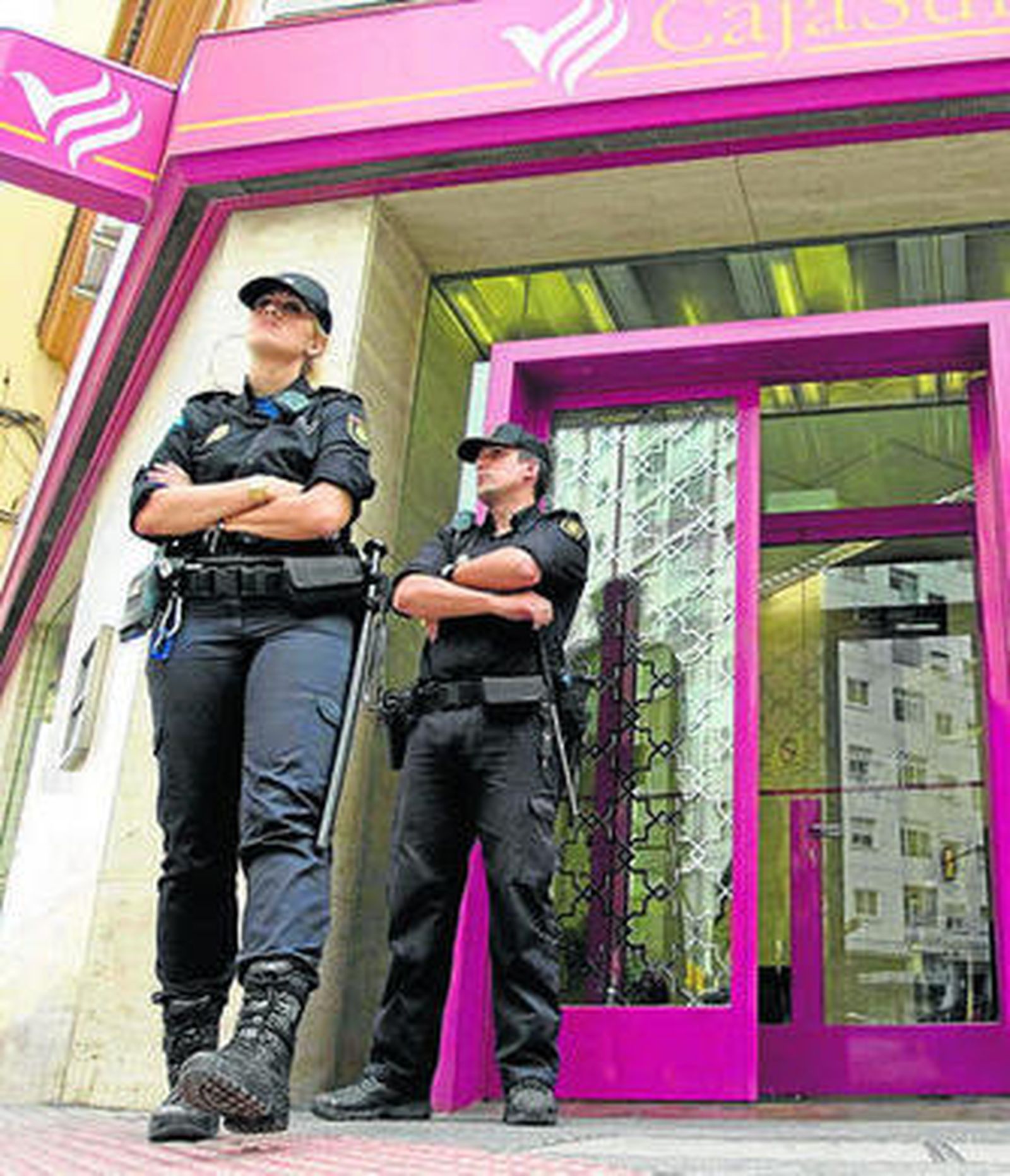Agentes en la puerta de una sucursal bancaria.