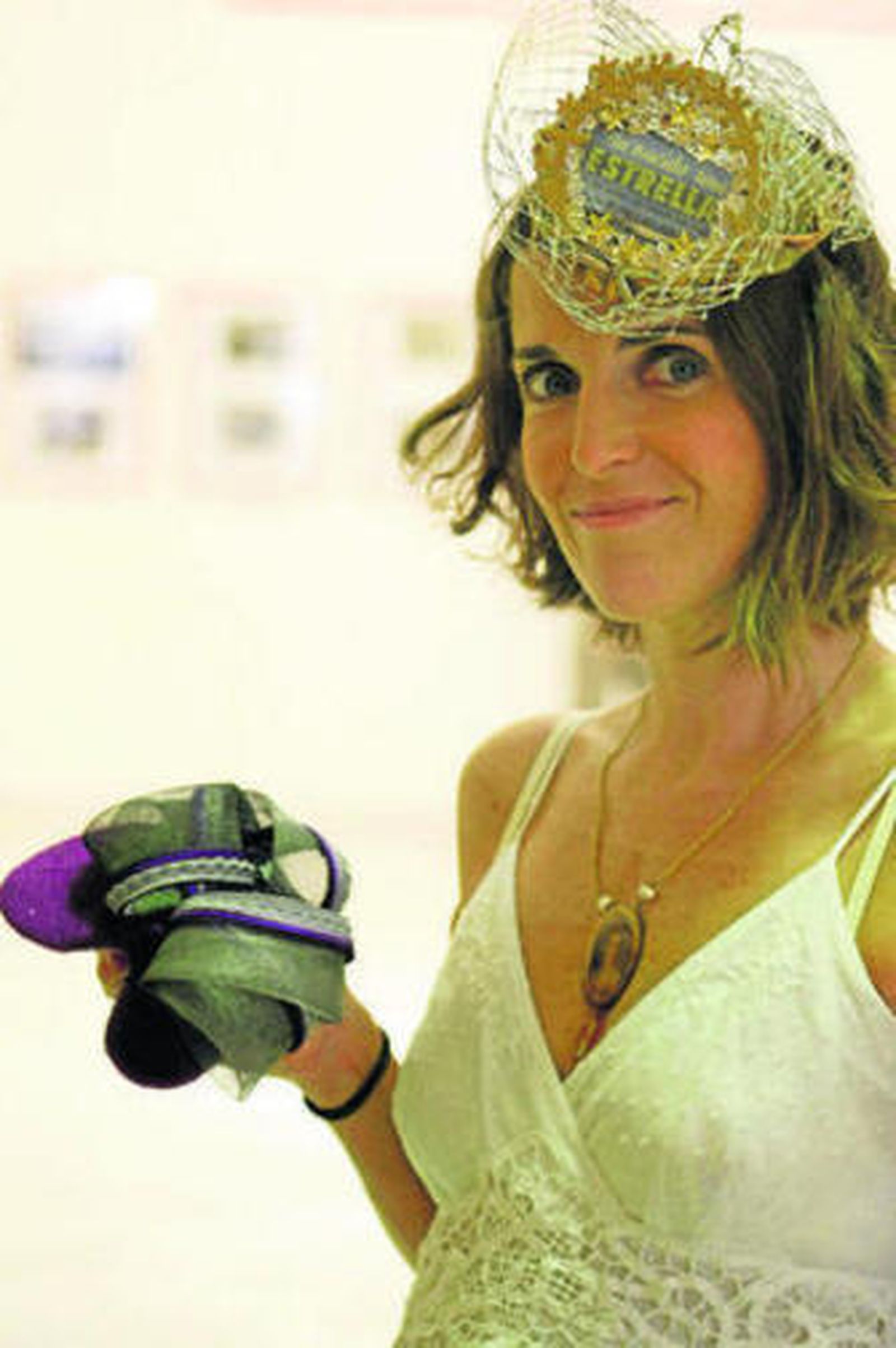 Mamen Osborne luciendo el tocado ganador y sujetando otro de sus modelos.