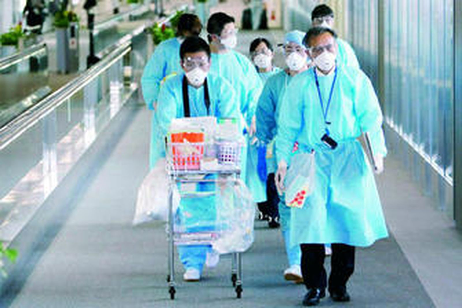 Médicos japoneses se dirigen al aeropuerto a recoger a tres personas contagiadas con la gripe A.