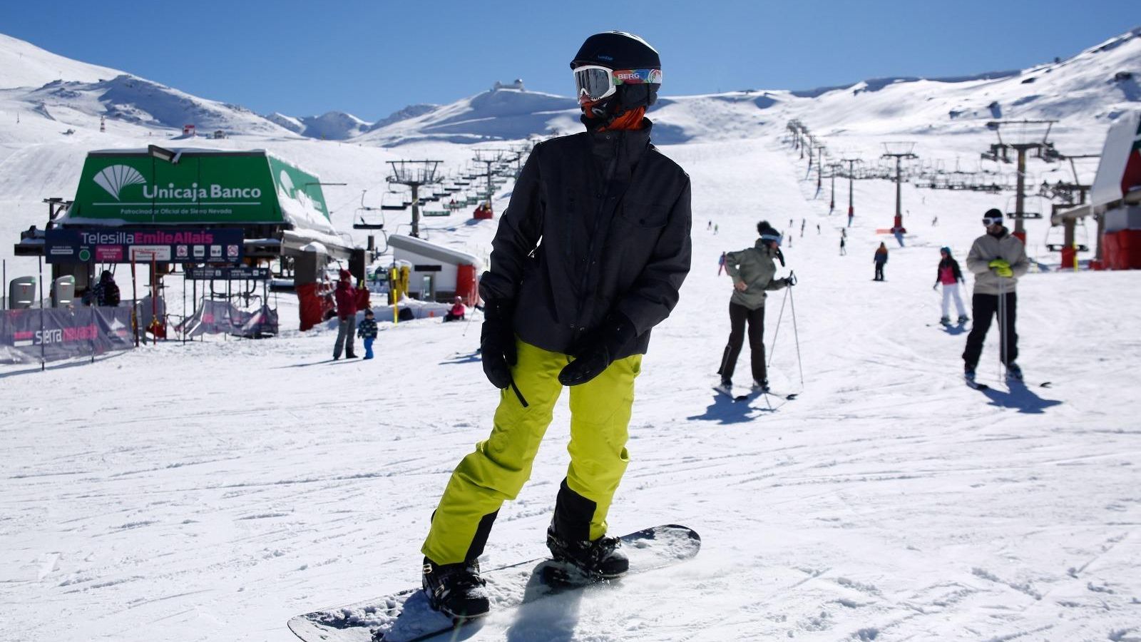 Un joven se desliza con su tabla de snowboard.