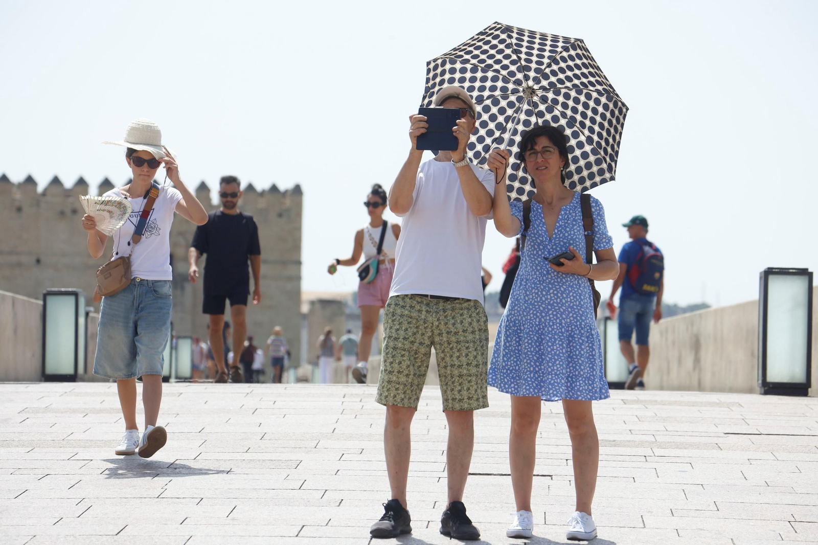 Turistas en una jornada de calor en el Puente Romano.