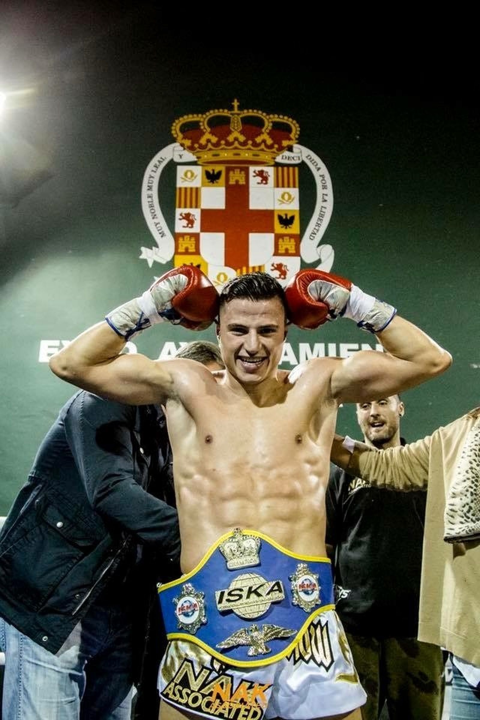 Martínez posa con el cinturón de campeón bajo el escudo de su ciudad.