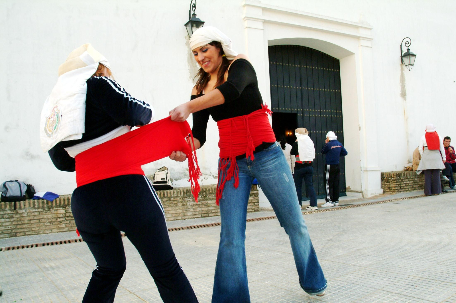 Dos costaleras se colocan la faja en un ensayo del paso del Cristo Yacente.