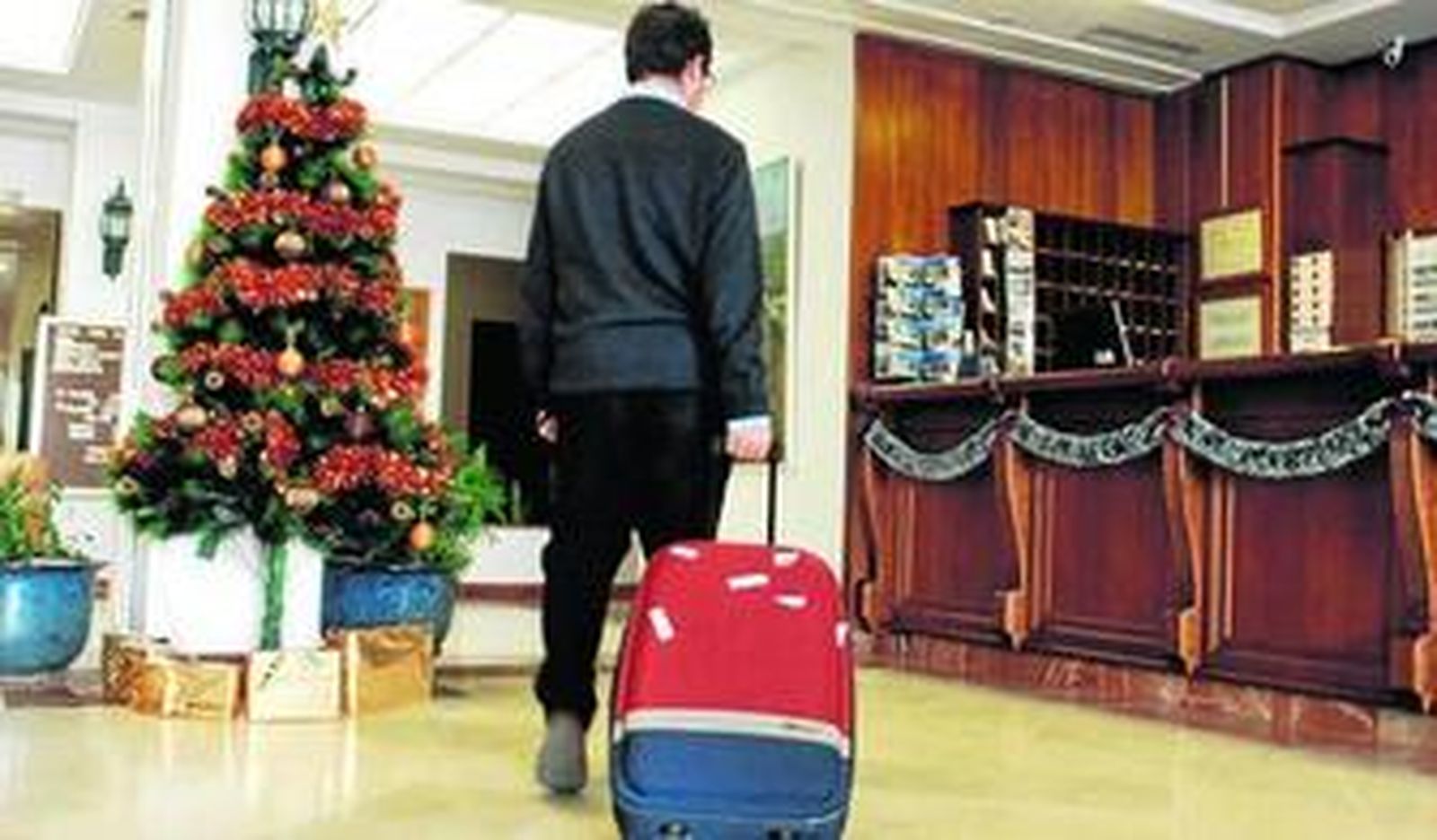 Un turista se acerca a  la recepción de un hotel en la Sierra para pernoctar.