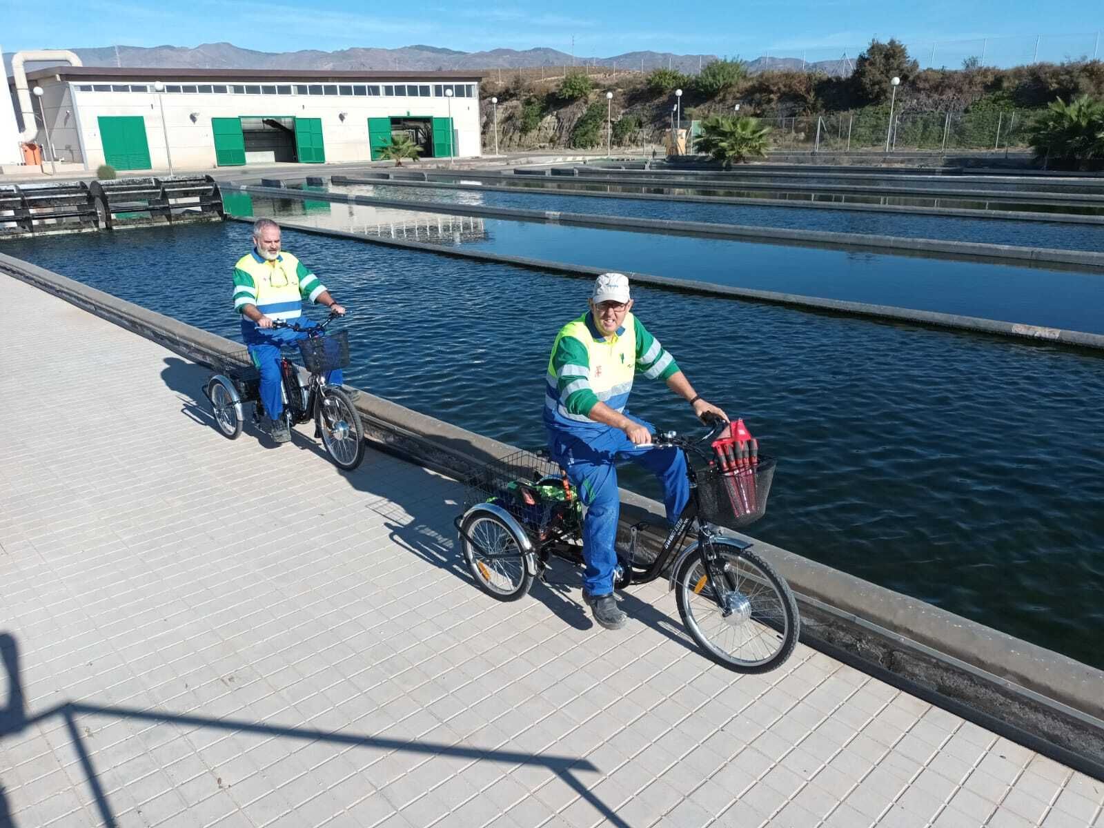 Dos trabajadores circulan sobre triciclos eléctricos