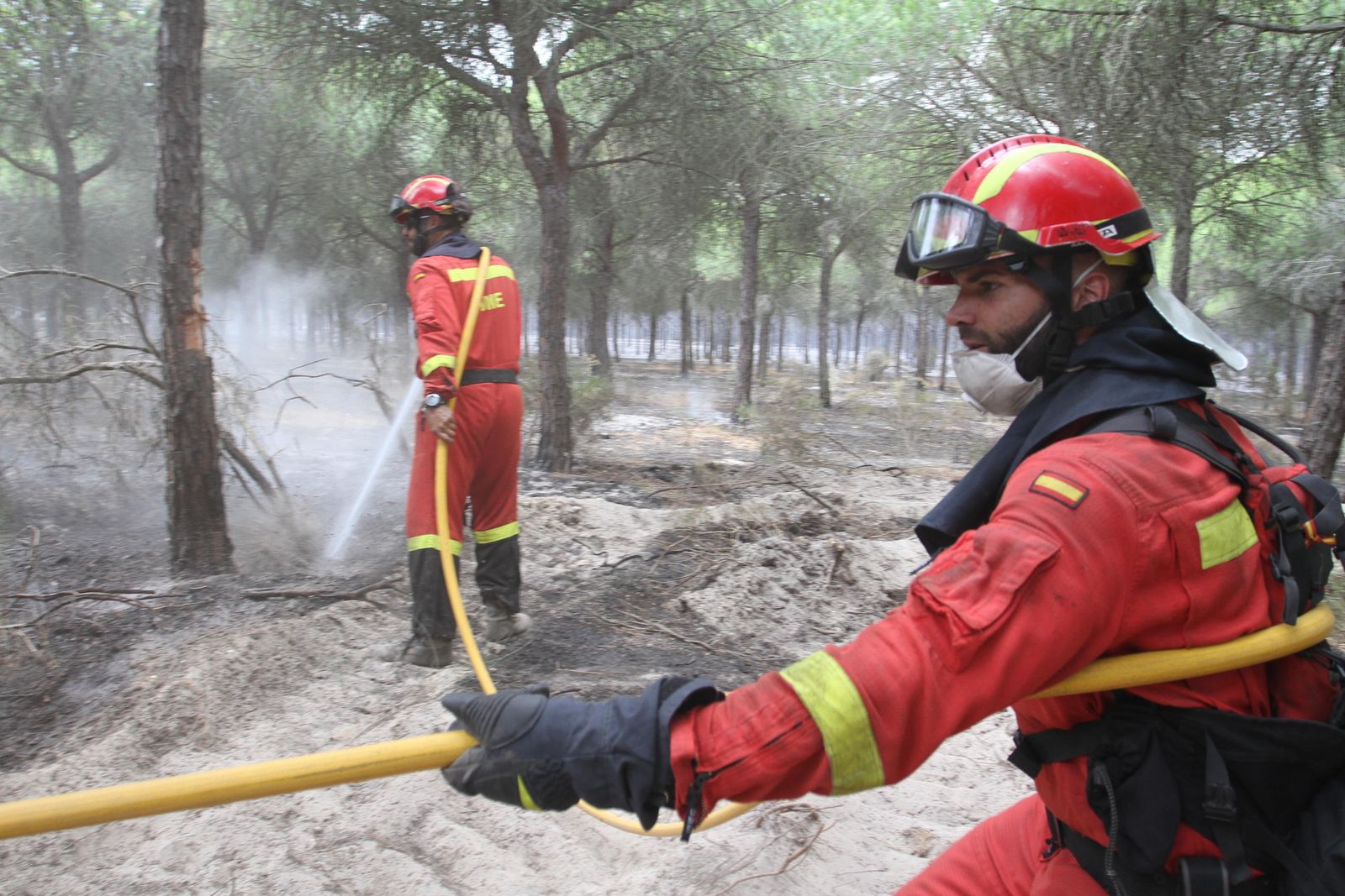 Miembros de la UME refrescan una de las zonas arrasadas por las llamas.
