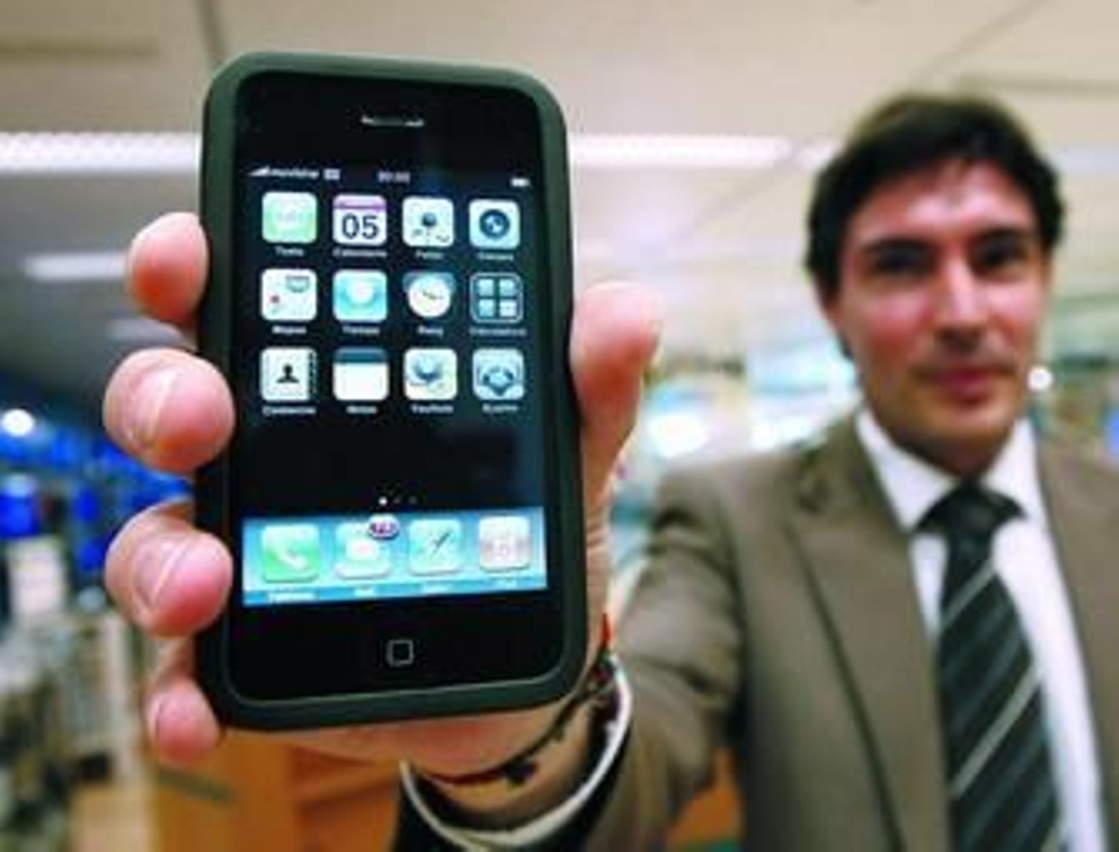 Antonio, de la tienda de telefonía de El Corte Inglés, sostiene un iPhone 3G, un móvil cuyo precio ronda los 300€ y que genera importantes listas de espera  para su adquisición.