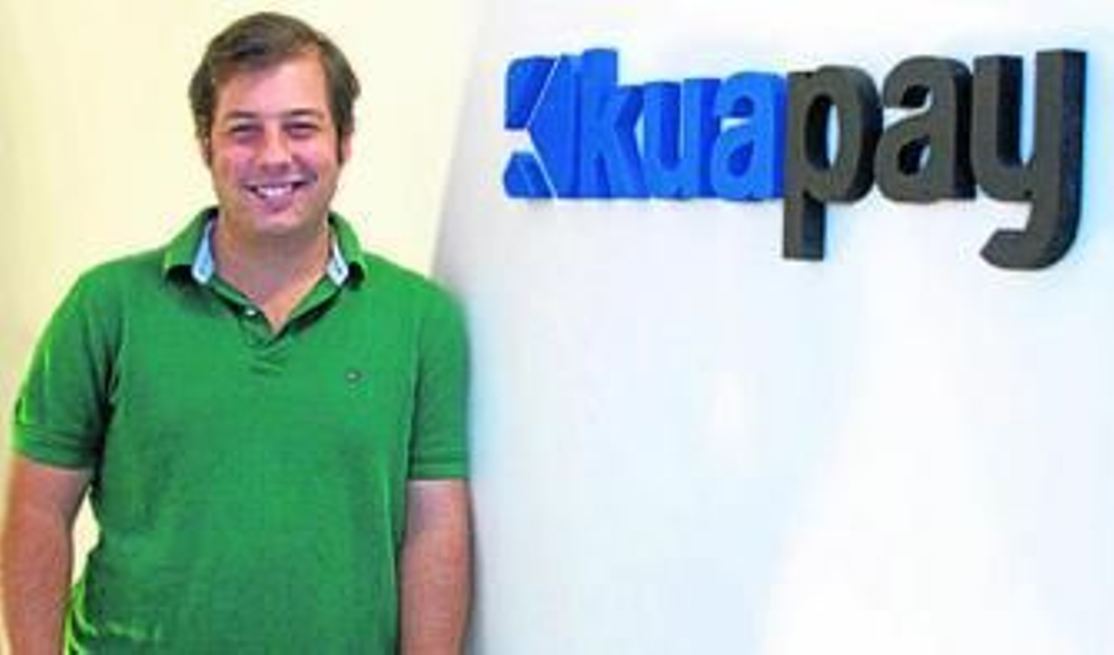 Joaquín Ayuso posa junto al logotipo de su actual empresa.