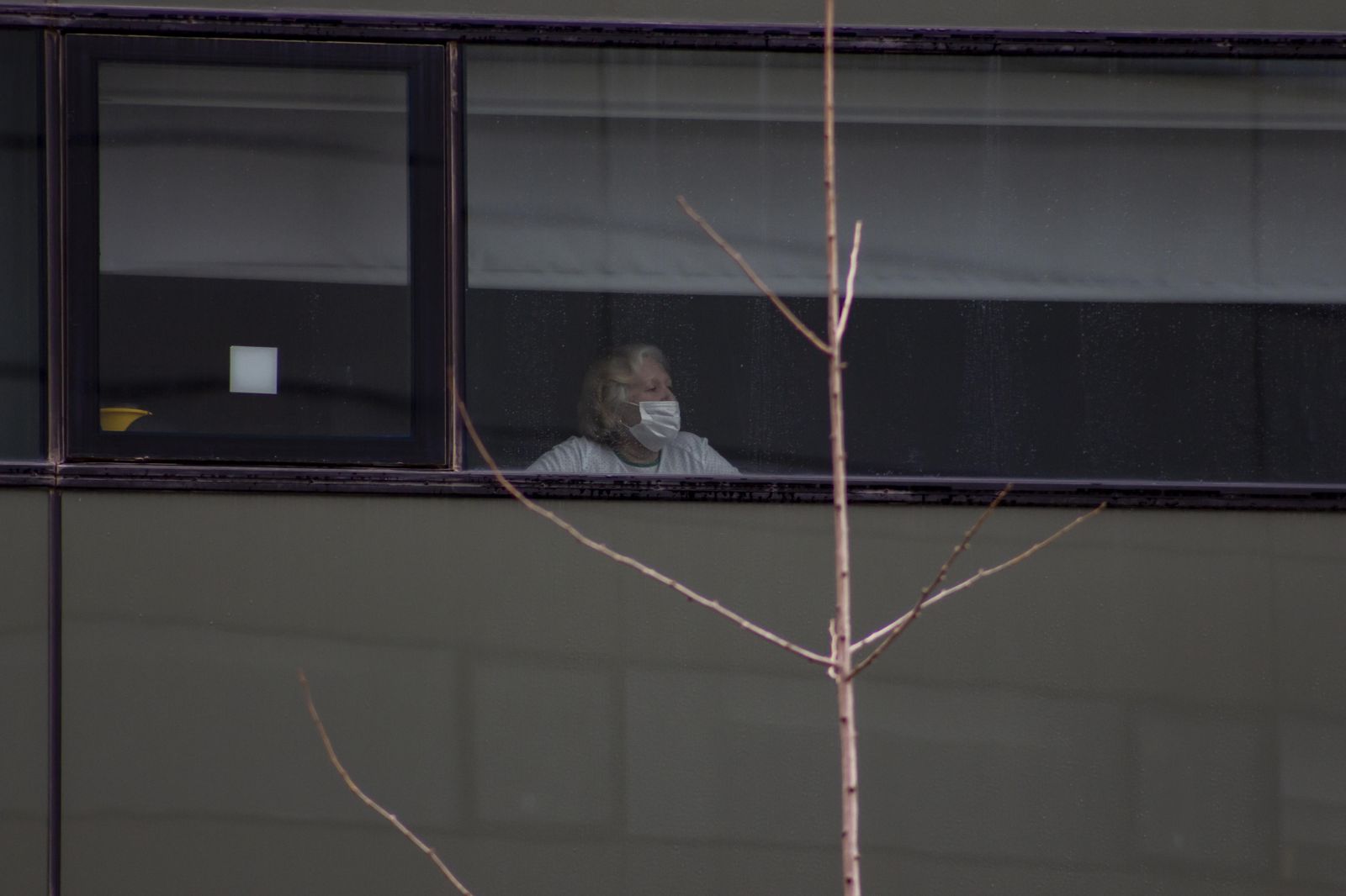 Una mujer mira al exterior de su habitación en el Hospital San Cecilio