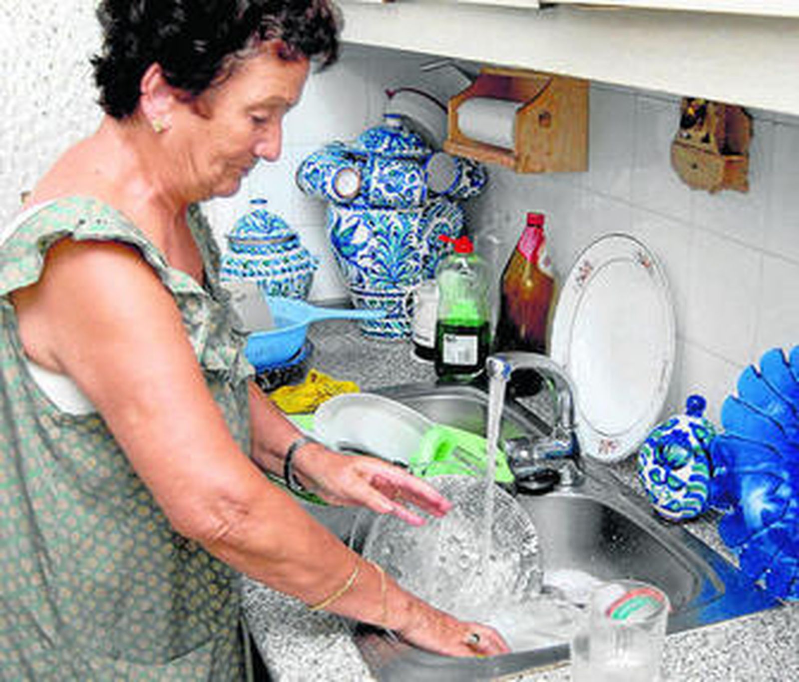 Una ama de casa friega los platos con técnicas para reducir el consumo de agua.