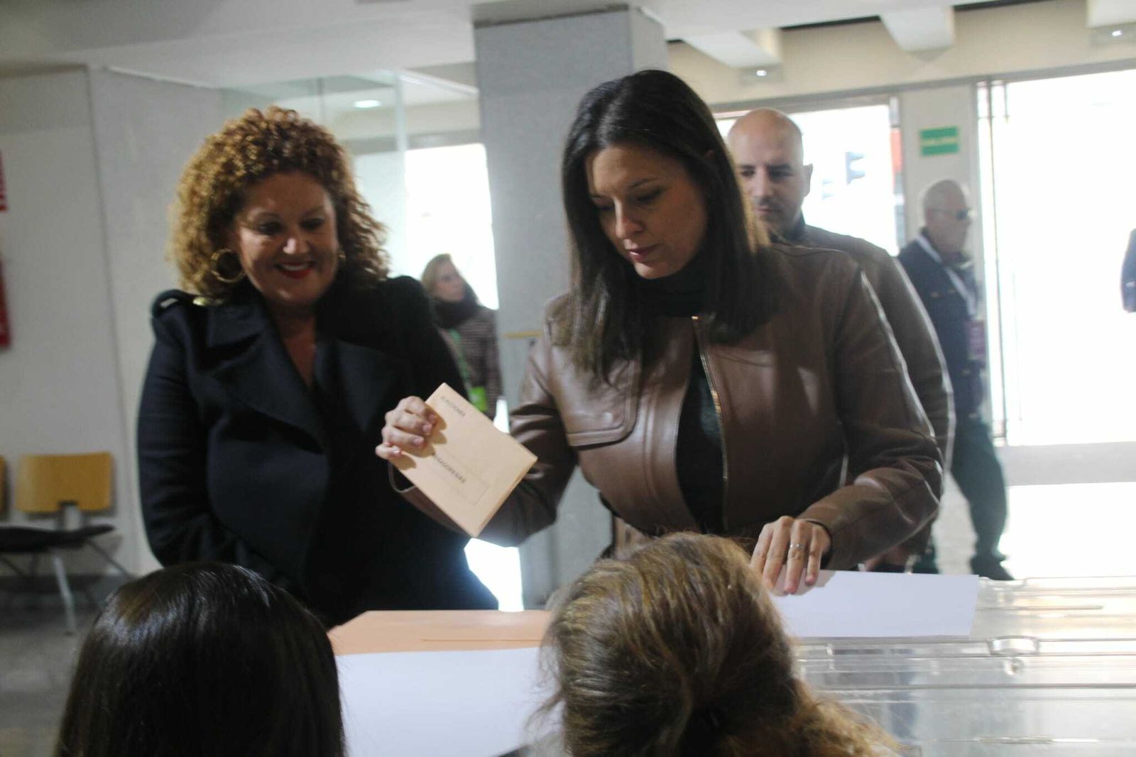 Patricia Cavada introduce su voto en las urnas, ante la mirada de Araceli Maese.
