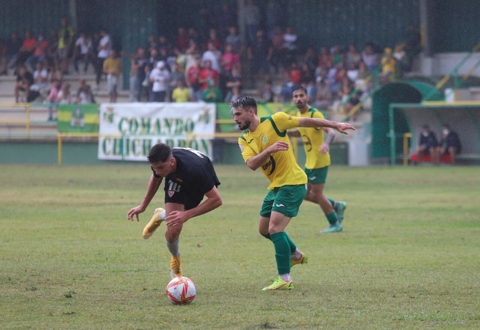 Una disputa del Unión-Sevilla C bajo la lluvia.