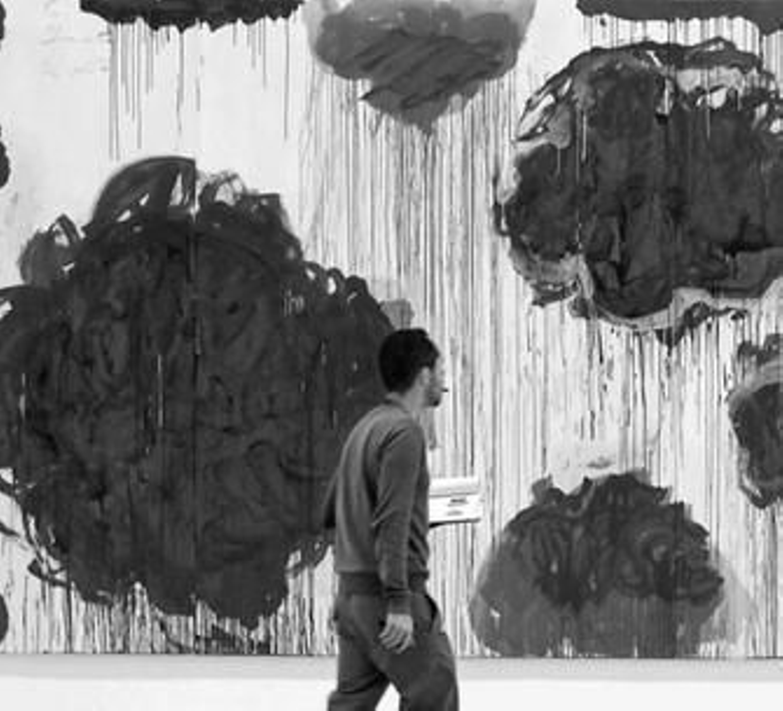 Un espectador contempla el lienzo 'Dispersión de flores y otras cosas', una de las obras expuestas.