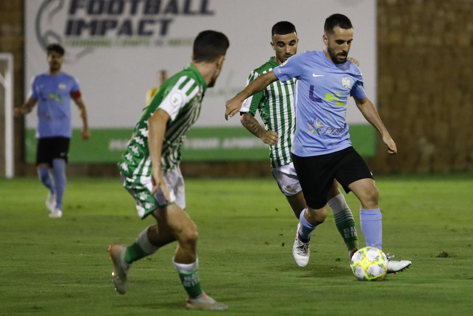 Mario Ruiz, del Ciudad de Lucena, trata de superar a dos béticos en la final del 'play off' de ascenso.