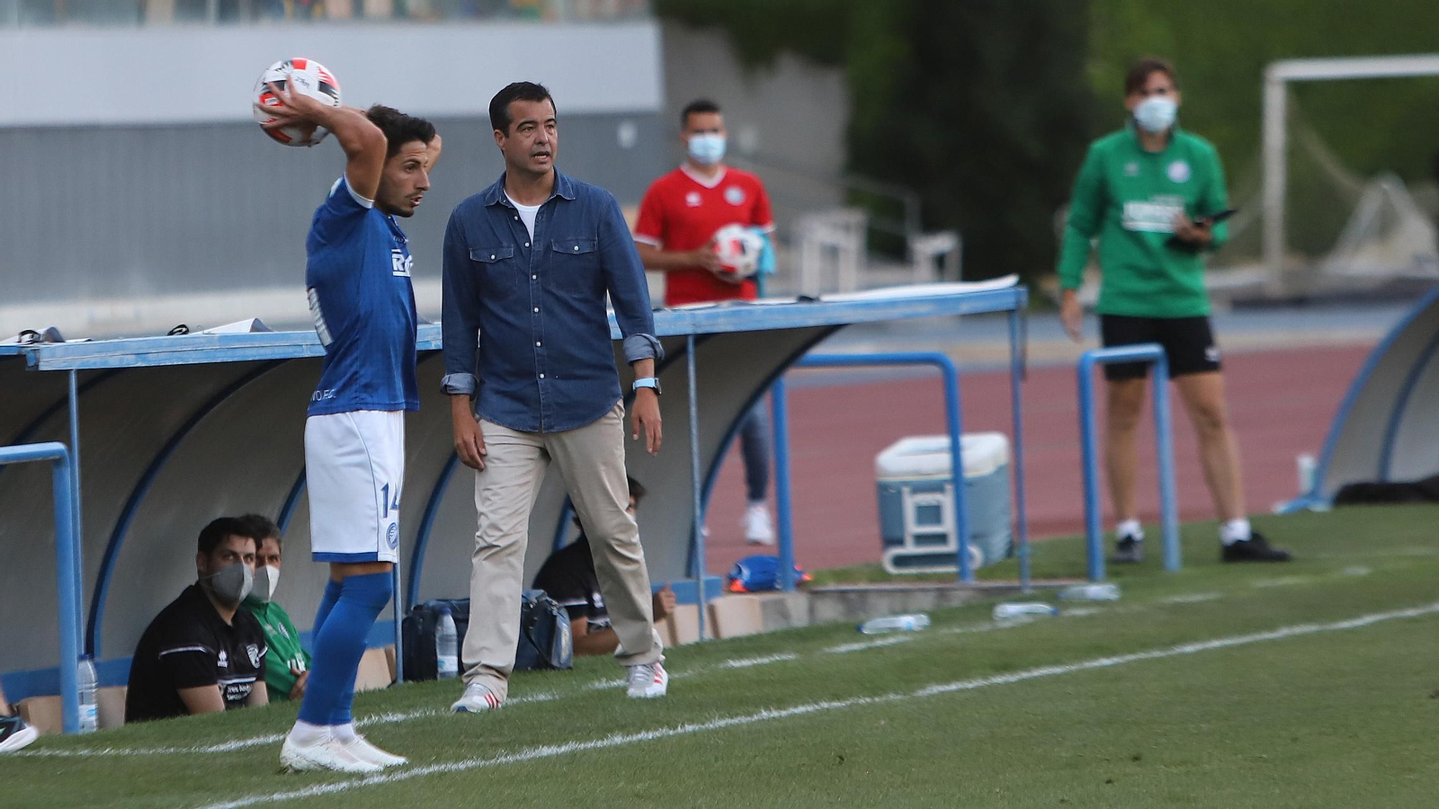 José Pérez, junto a Javilillo, que se dispone a sacar de banda al lado del banquillo.