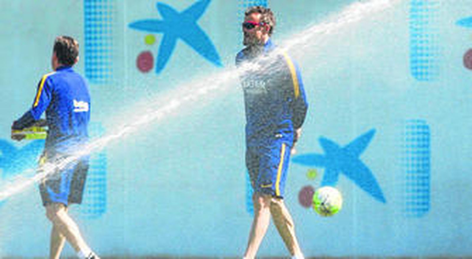 Luis Enrique pasa por una boca de riego durante el entrenamiento realizado por el Barcelona en la mañana de ayer.