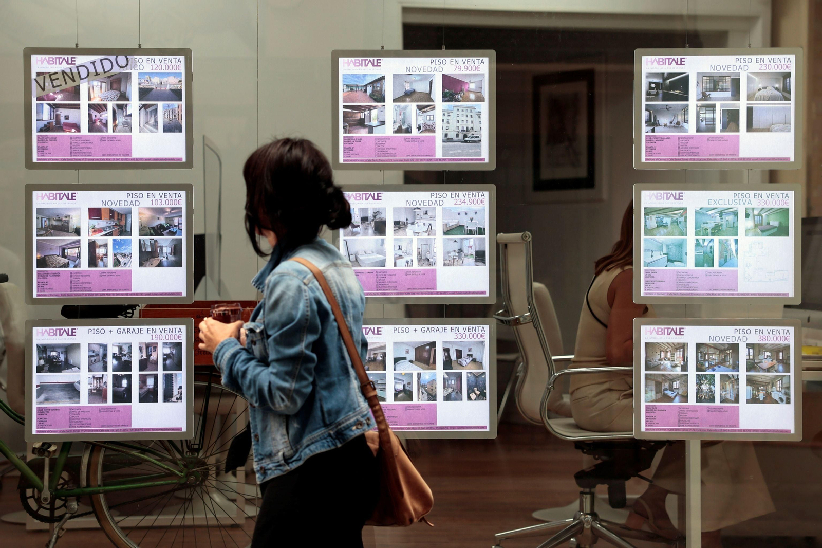 Una mujer se fija en unos anuncios de una inmobiliaria en una imagen de archivo.